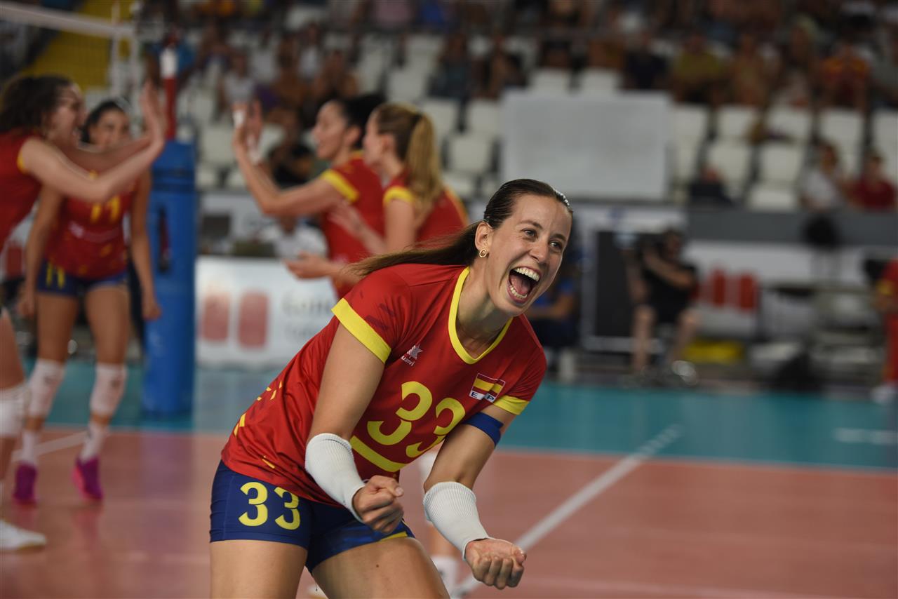 Volleyball match action with players at the net, possibly Spain vs Portugal.