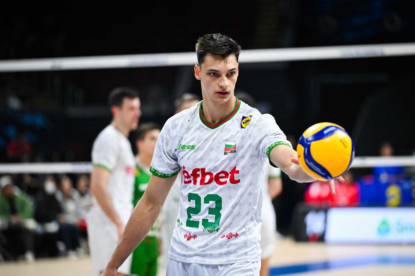 Bulgarian men`s volleyball team in action, blocking at the net.