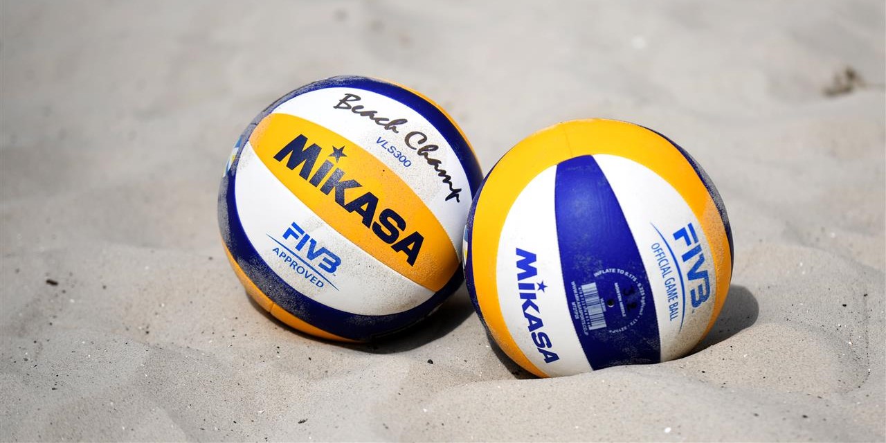 Beach Volleyball players in action on a sunny court.