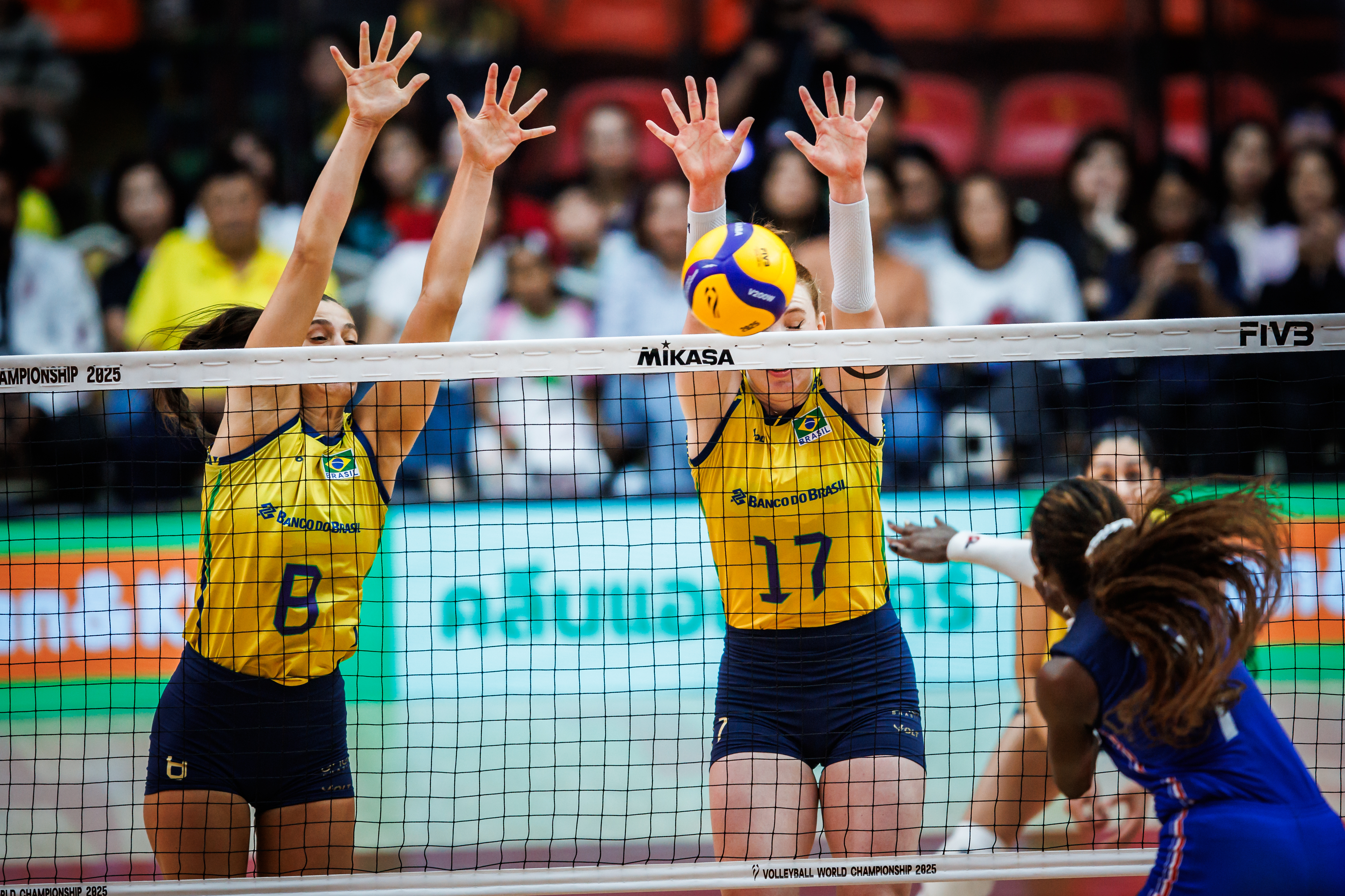 Volleyball match action with a ball in the air