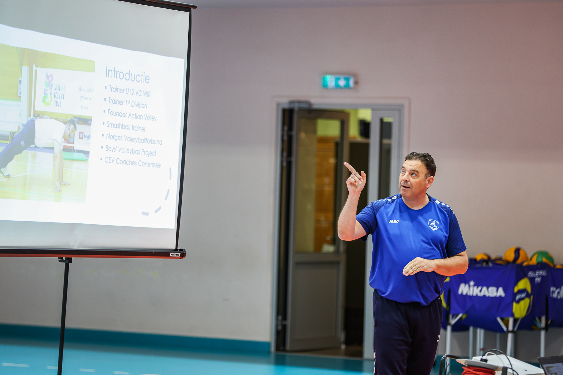 Coaches and children participating in a group activity during the volleyball training.