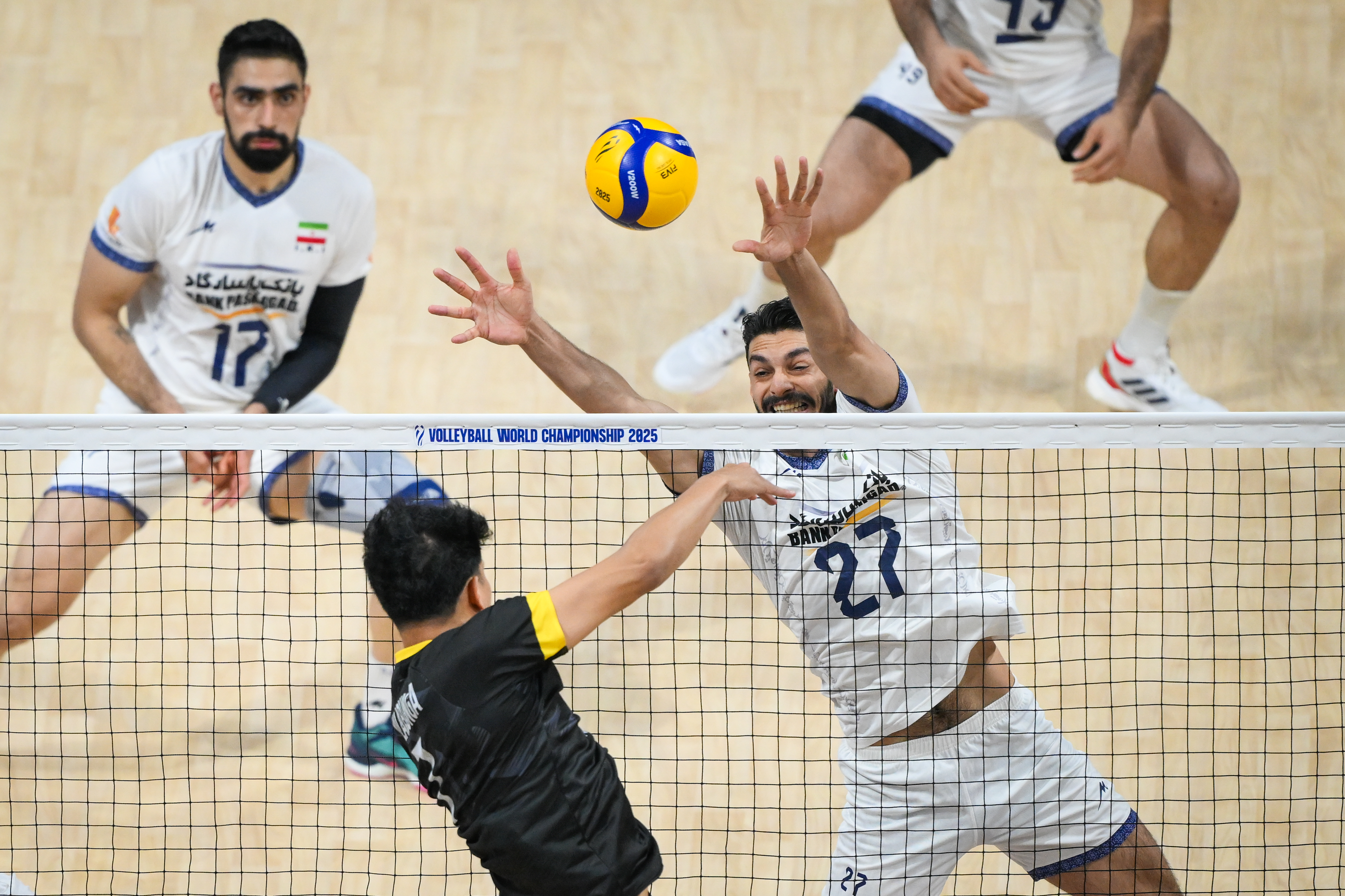 Volleyball match action with players mid-air