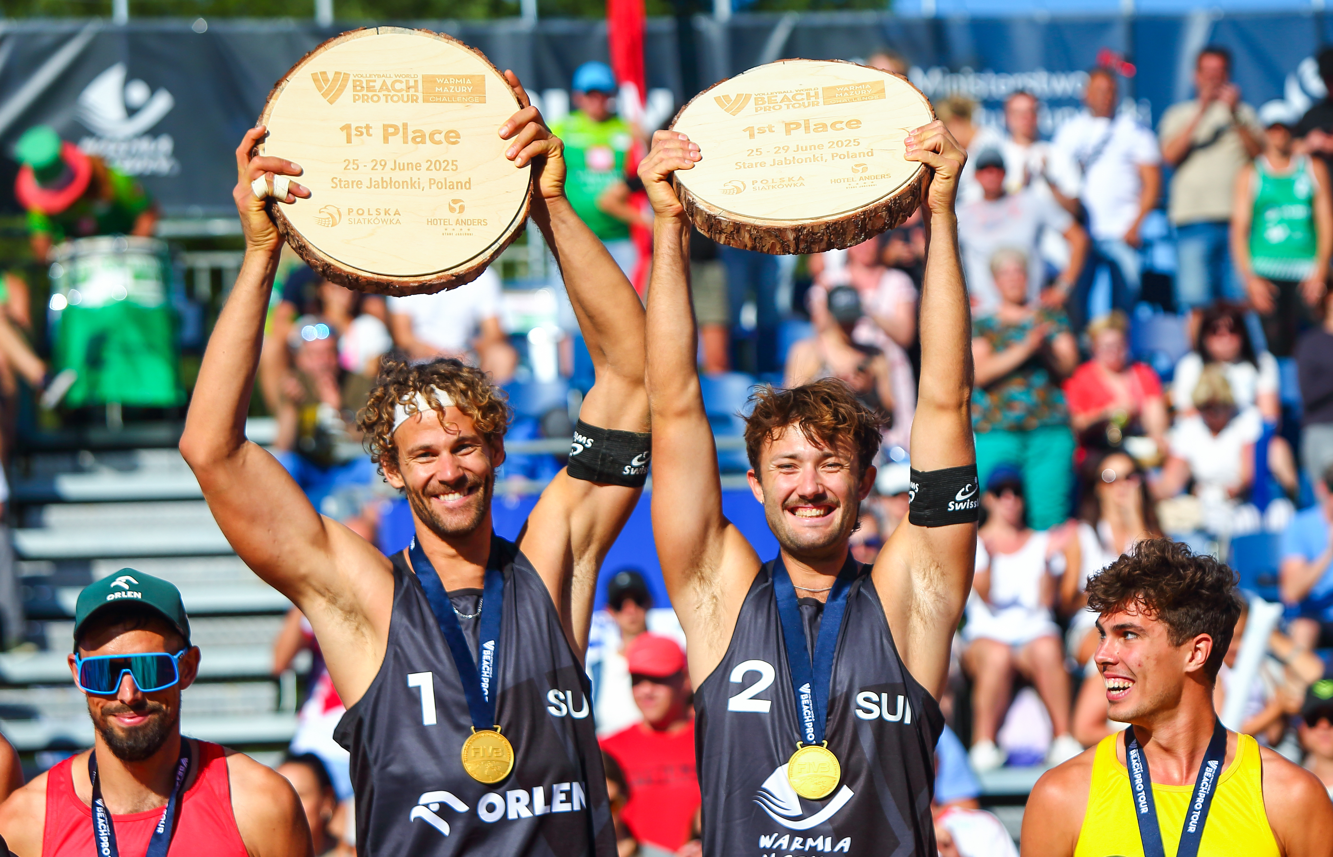 Swiss beach volleyball players Marco Krattiger and Leo Dillier celebrate winning the final.